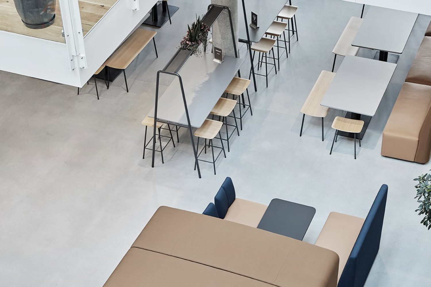 An aerial view of an office with work booths, office tables and chairs.