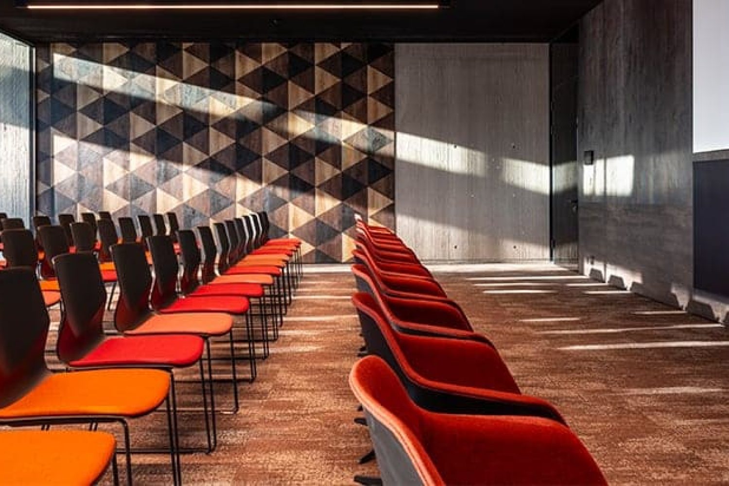 A conference room with rows of chairs and a projection screen.