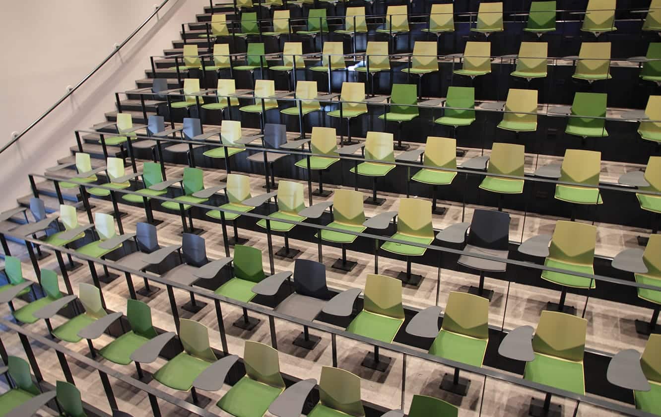 A row of green and yellow chairs in an auditorium.