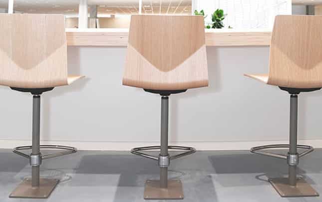 Three wooden bar stools in front of a counter.