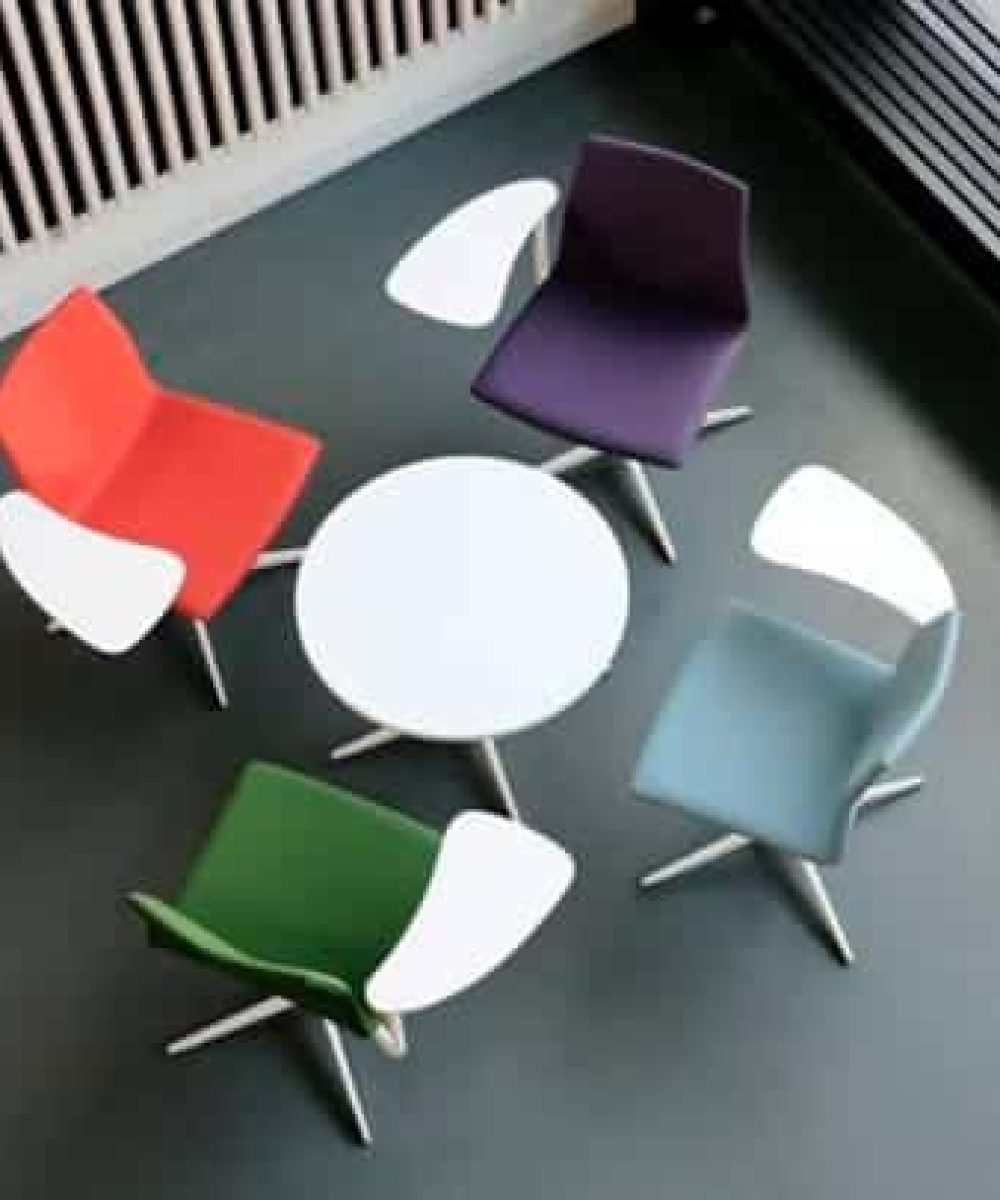 A group of colourful chairs arranged around a table.