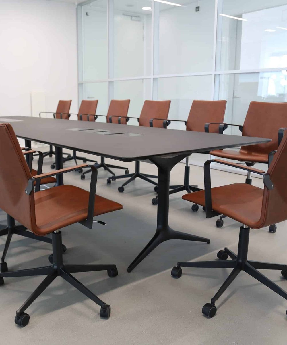 A conference table and office desk chairs in a conference room.