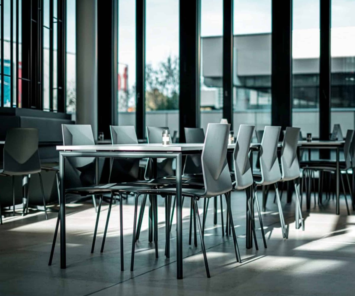 A table with chairs in front of a large window.