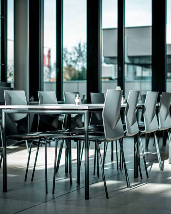 A table with chairs in front of a large window.