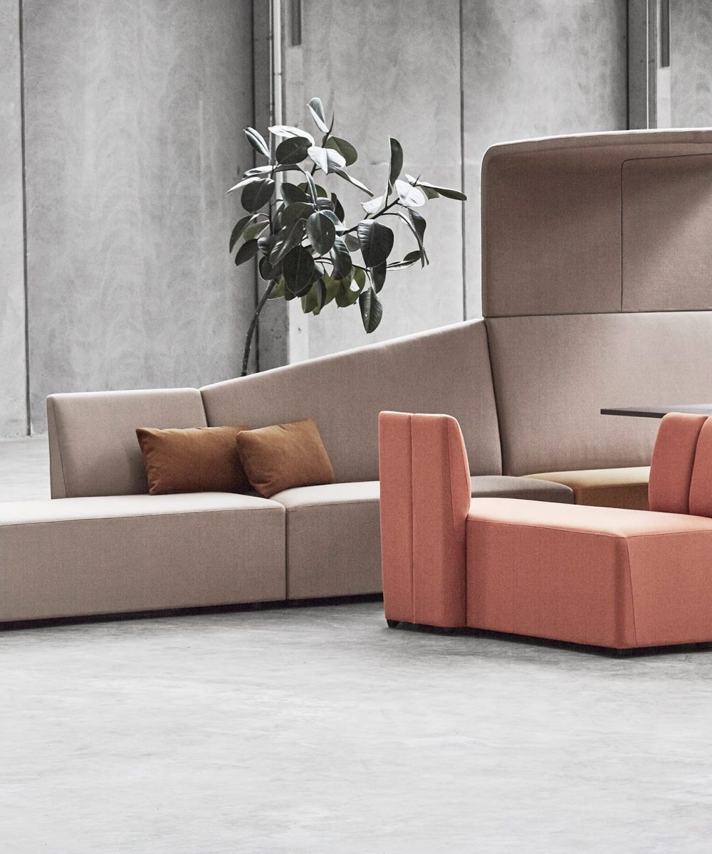 A group of office work booths, chairs and couches in an office space.