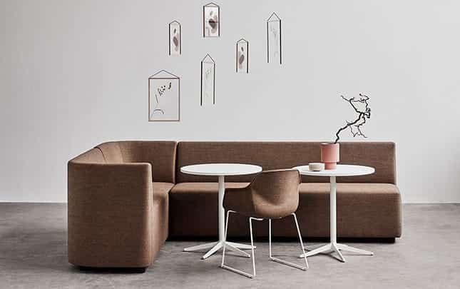 Office sofas, table and chairs in a room with a tree.
