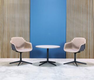 Two chairs and a table in front of a blue wall.