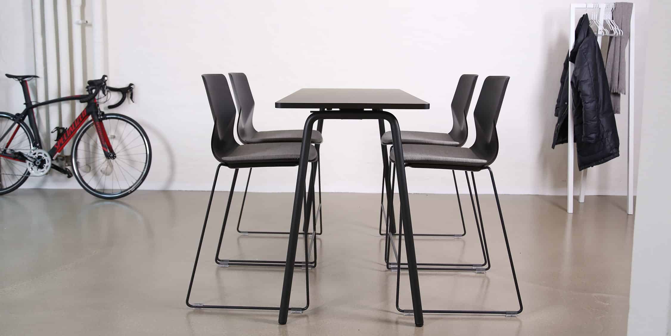 A white table and counter chairs in front of a white wall