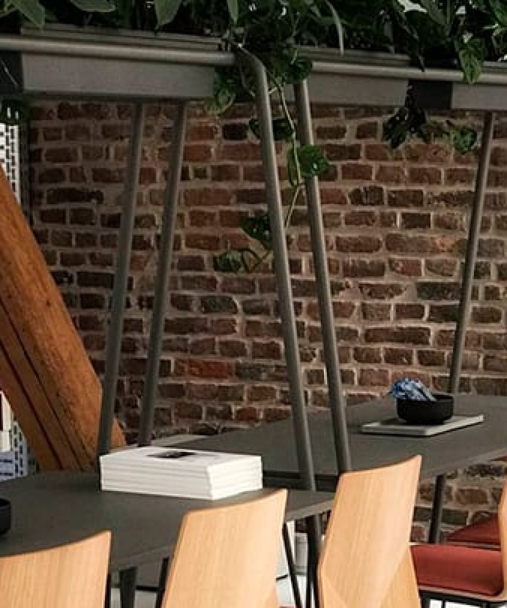 Community tables with stools and chairs in an office.