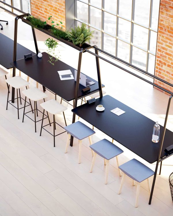 An office with community tables, chairs, and a window.