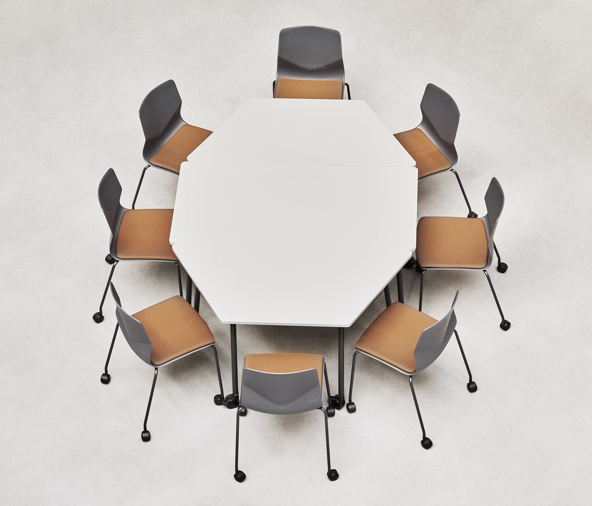 An octagonal table with six office desk chairs around it.