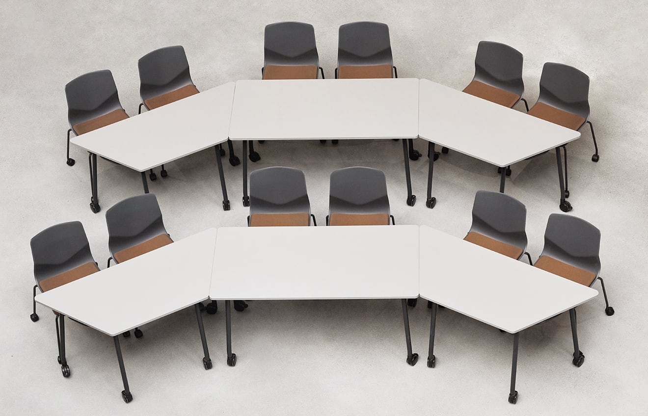 A group of chairs and office tables arranged in a semi circle.