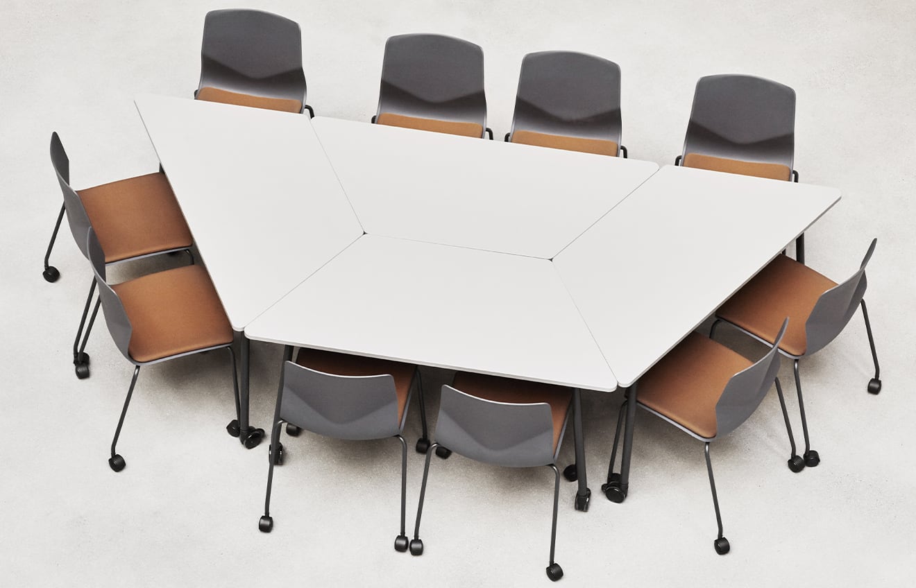 A conference table with office desk chairs around it.