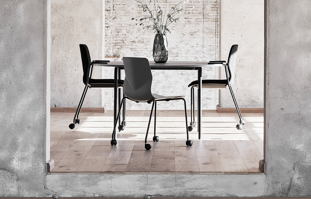 A dining room with a table and office desk chairs on wheels