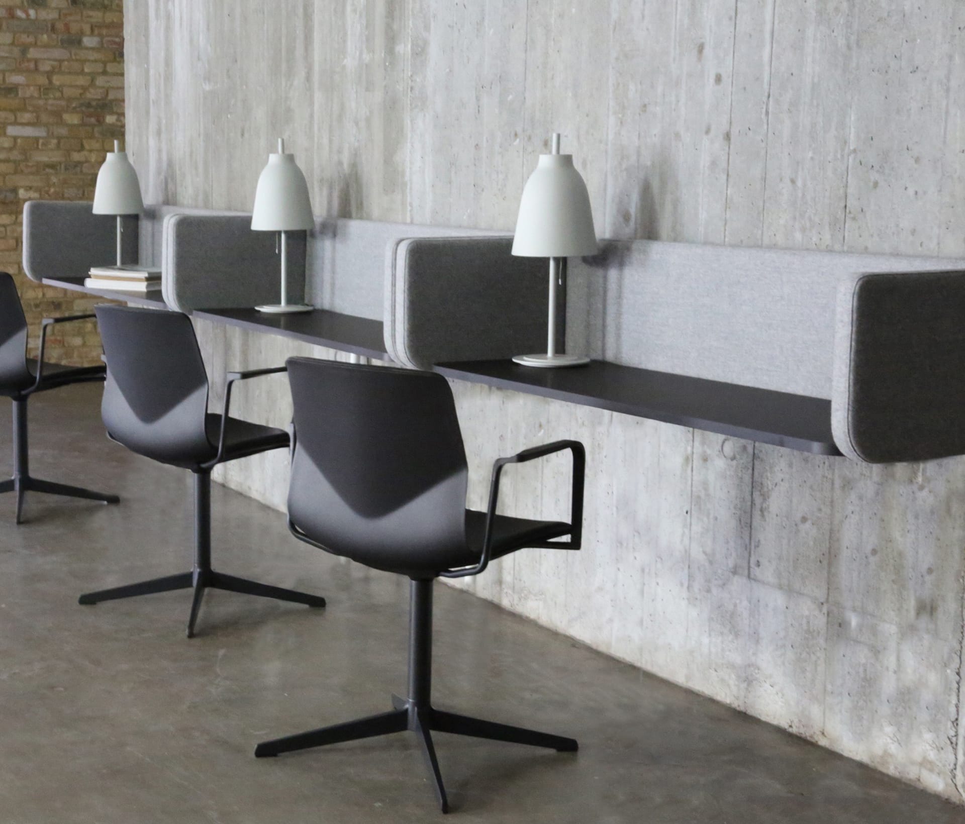 A chair and three wall mounted desk workstations