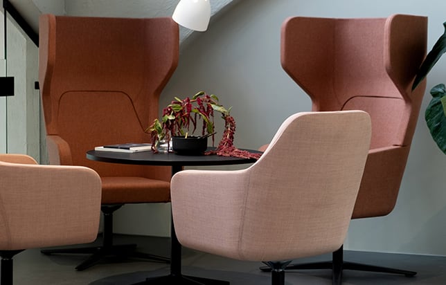 A group of lounge chairs for offices in a room with a table.