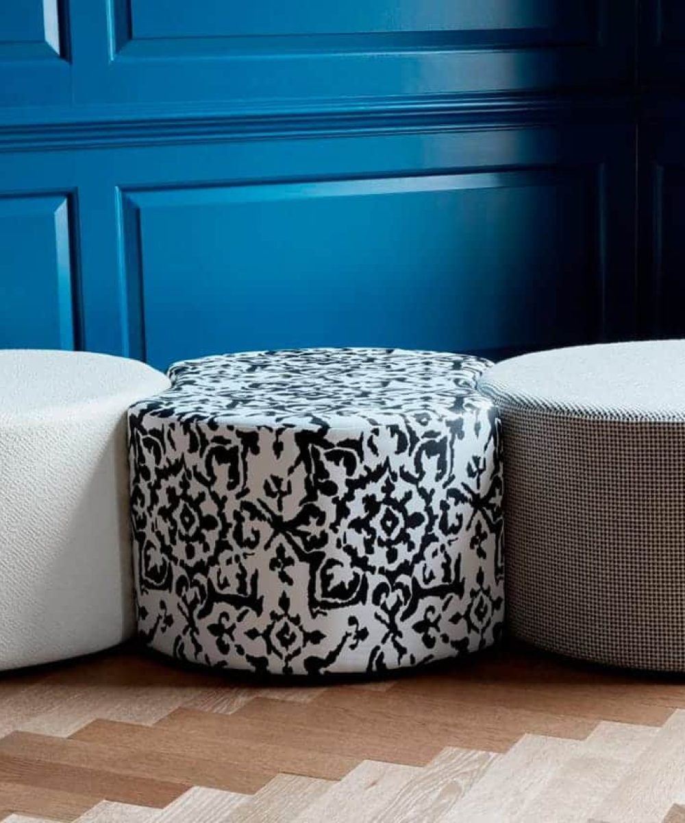 Three office stools in front of a blue wall.