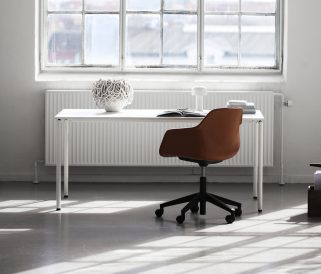 A white desk with an orange chair in front of a window.