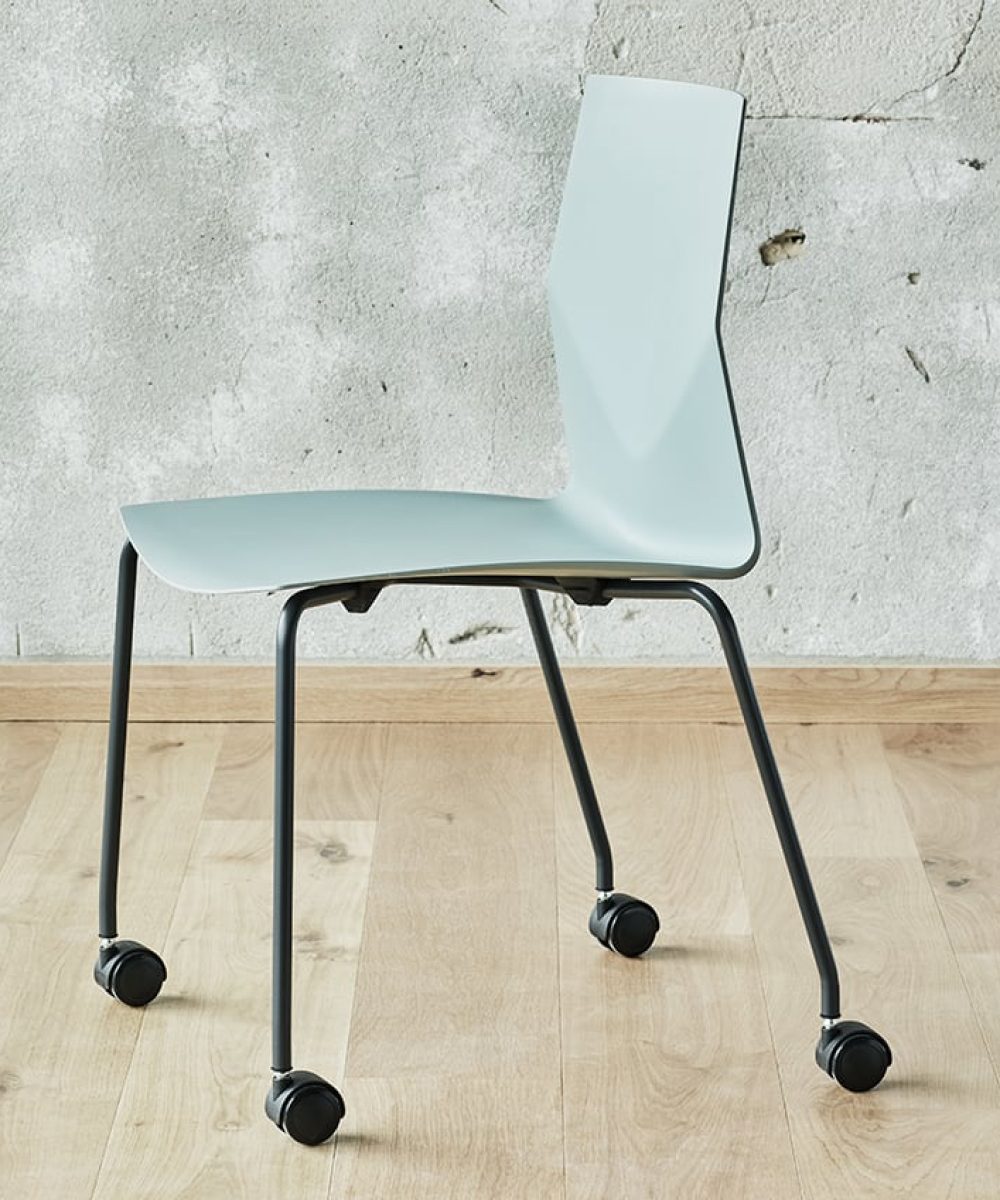 A light blue chair on wheels in front of a wall.