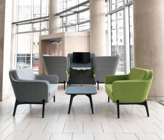 A group of lounge chairs for offices in a lobby with large windows.