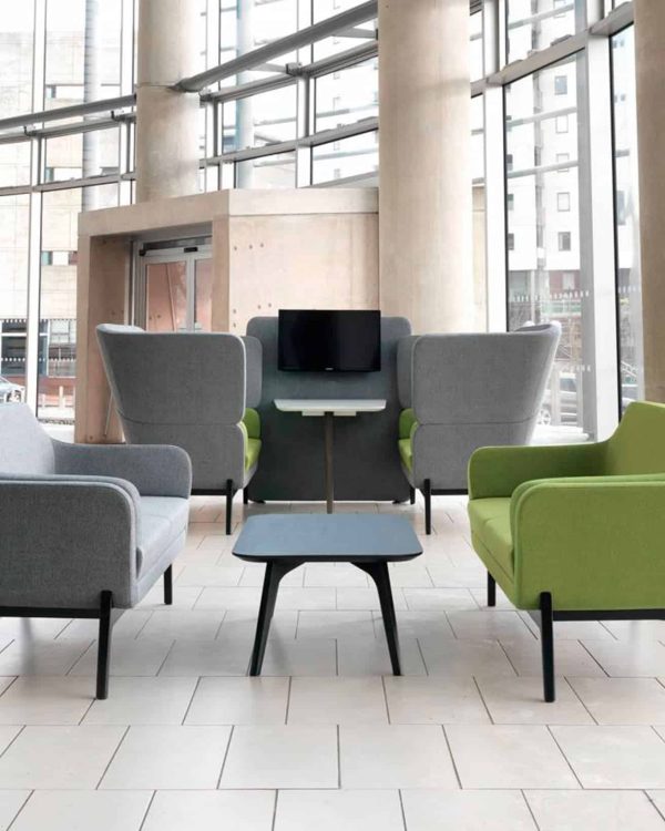 A group of lounge chairs for offices in a lobby with large windows.