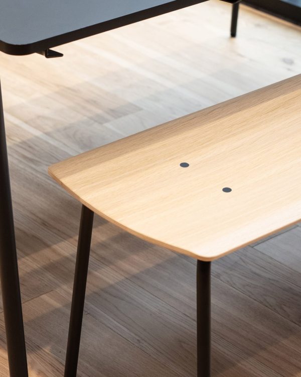 A wooden bench with a black top and black legs.