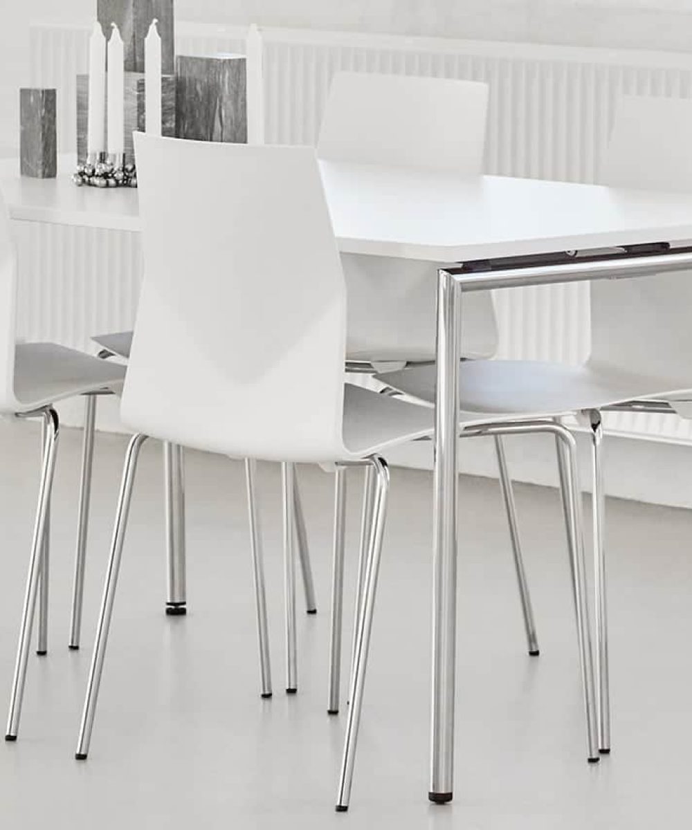 White canteen furniture and chairs in a room with a radiator.