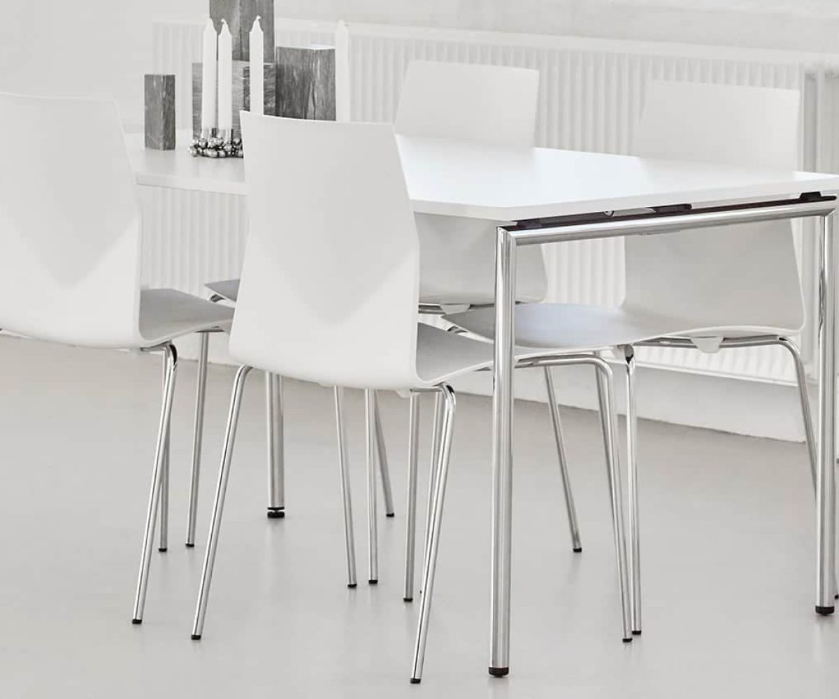 White canteen furniture and chairs in a room with a radiator.