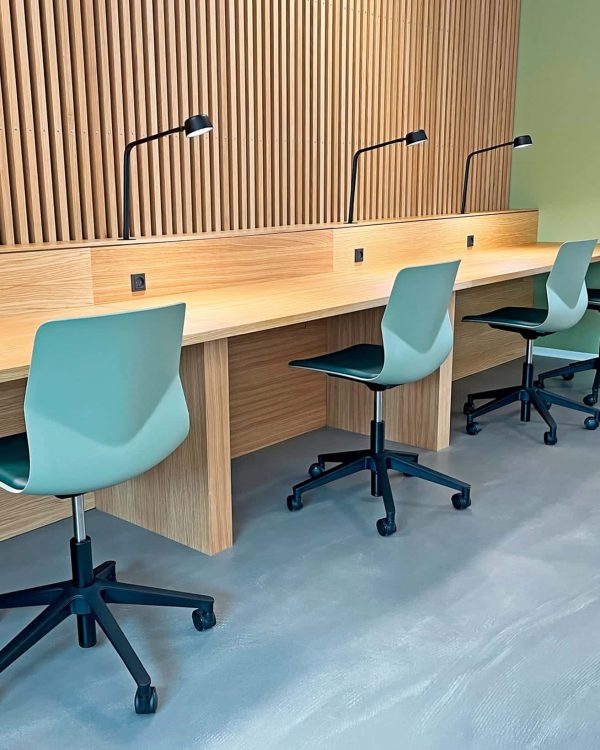 Study booths, desk workstations and chairs in an office.