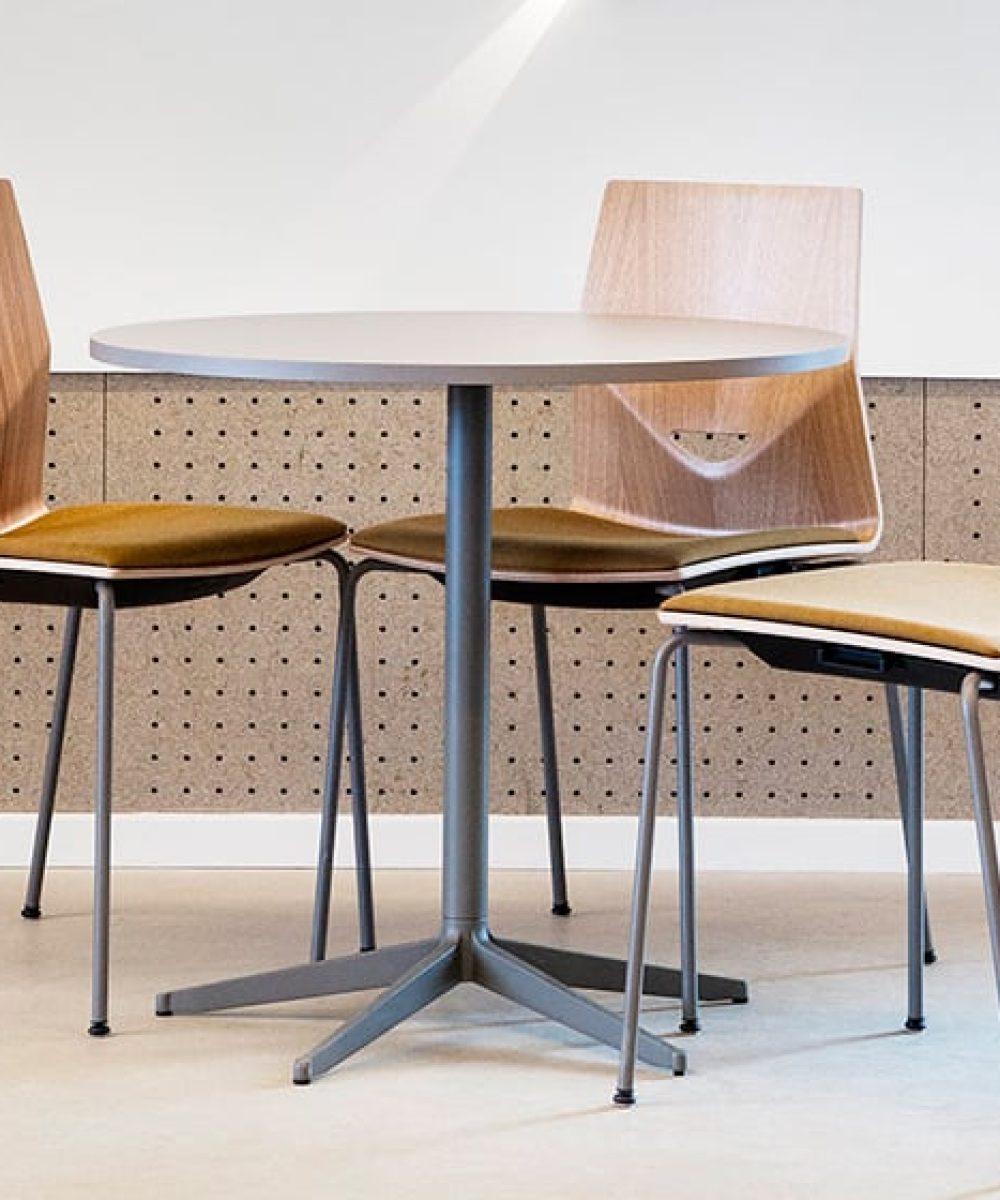 Three office desk chairs and a table in a room.