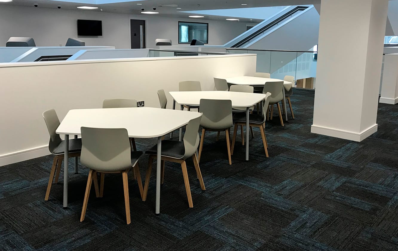 A room with hexagonal tables and office desk chairs in it.