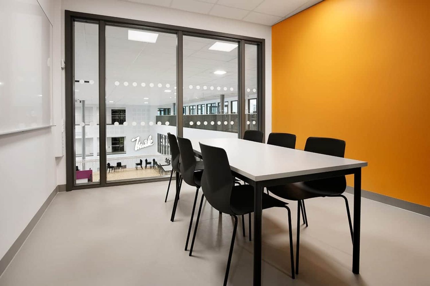 A conference room with a large conference table and office desk chairs.