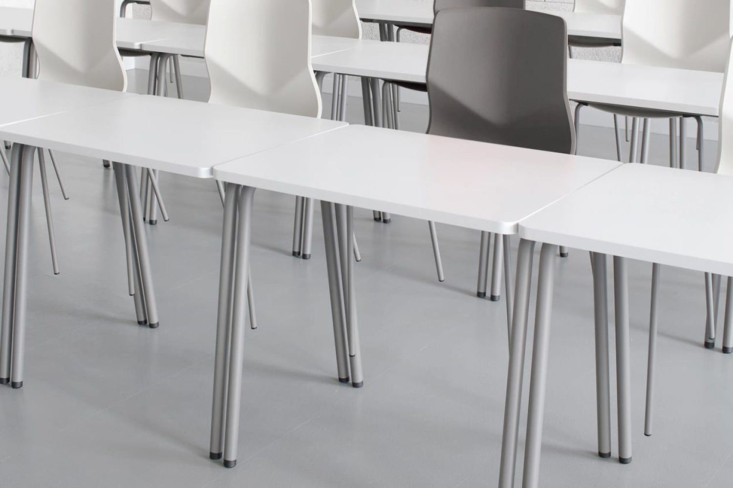 A group of office desk chairs and office tables in a lecture hall