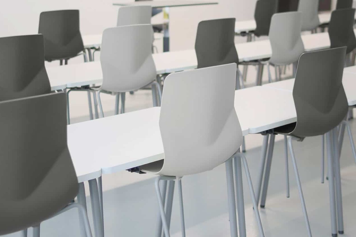 A group of office desk chairs and office tables in a lecture hall