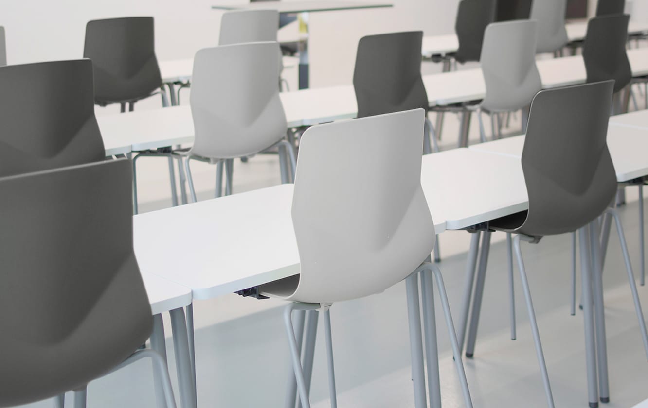 A group of office desk chairs and office tables in a lecture hall