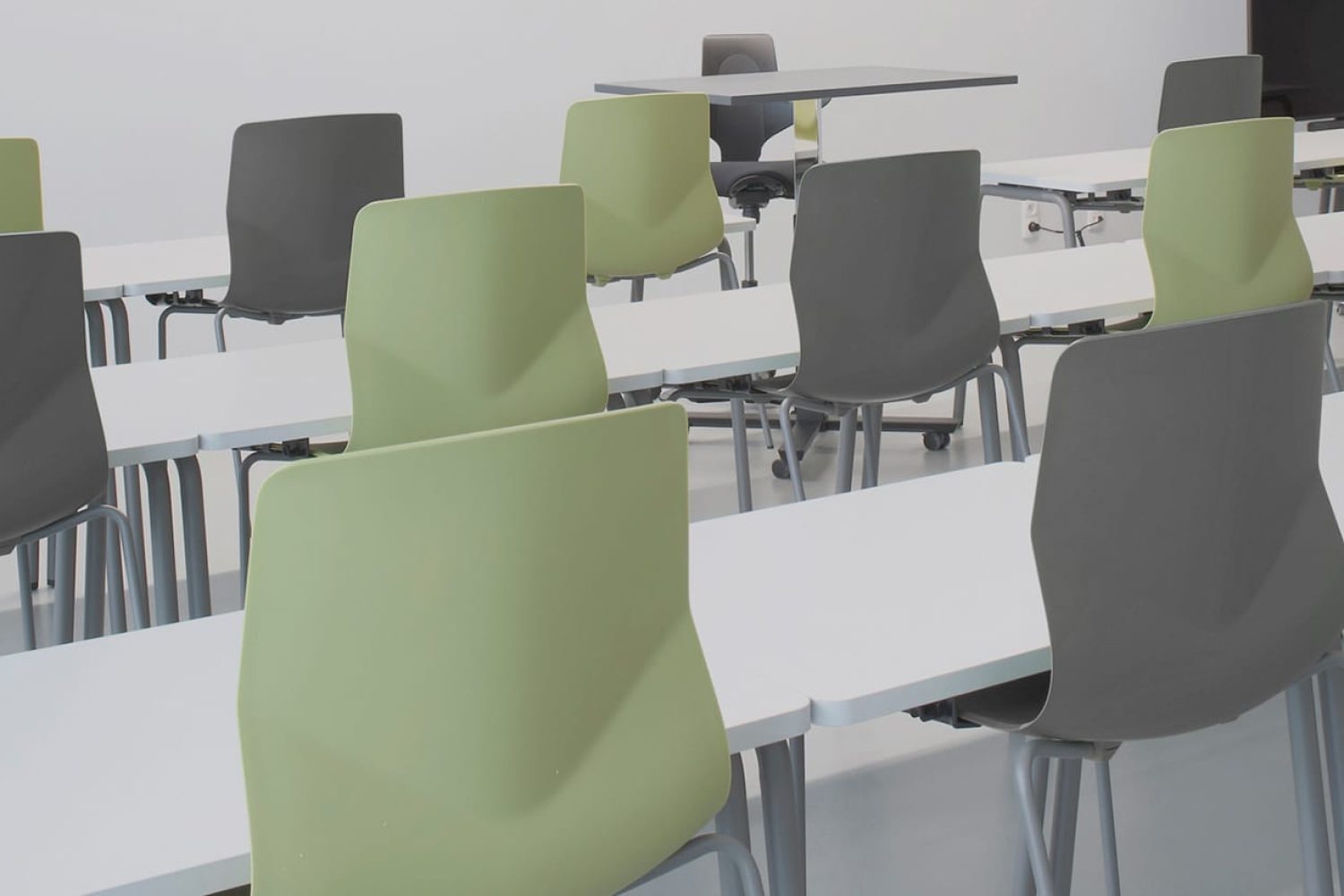 A group of office desk chairs and office tables in a lecture hall