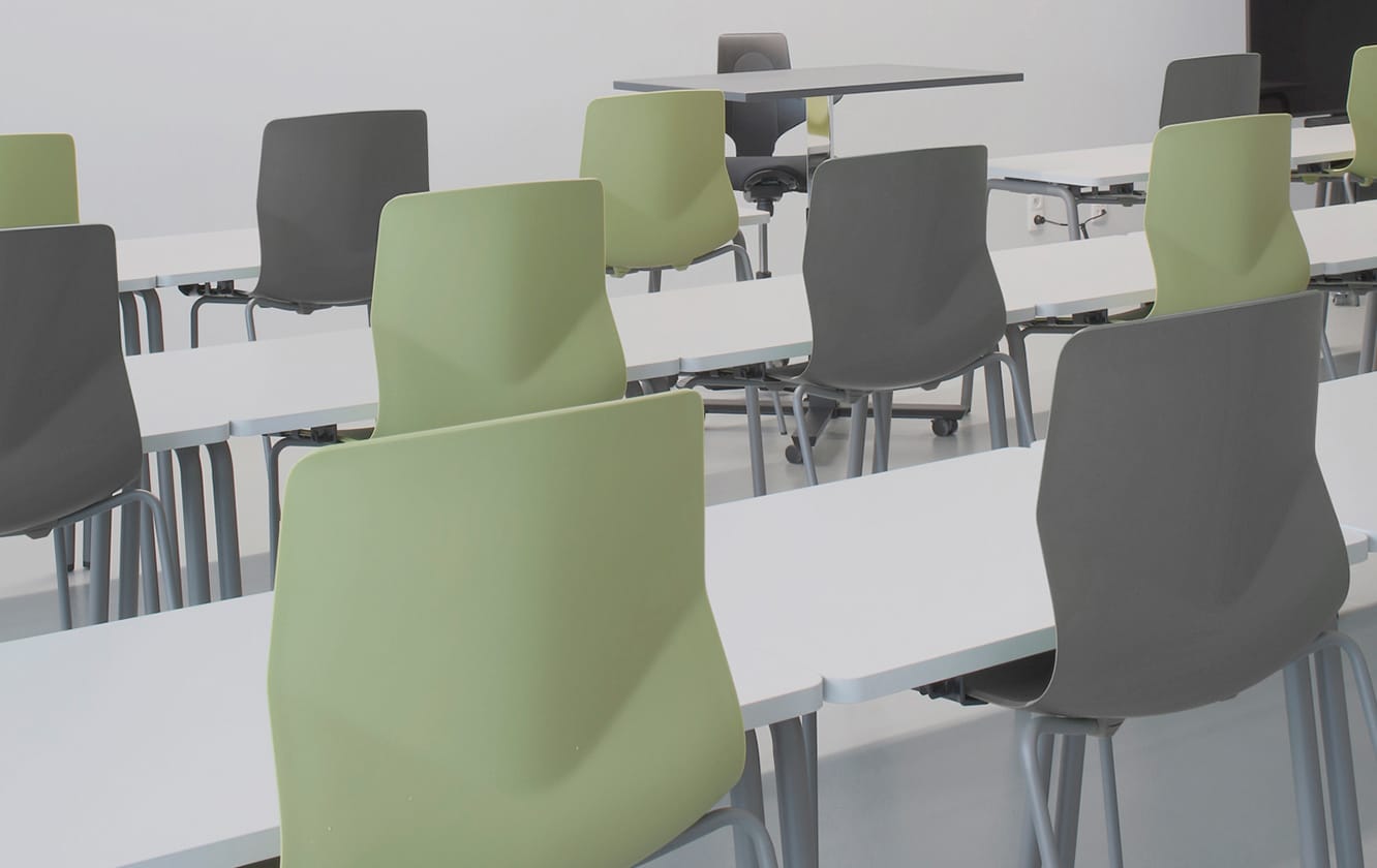 A group of office desk chairs and office tables in a lecture hall