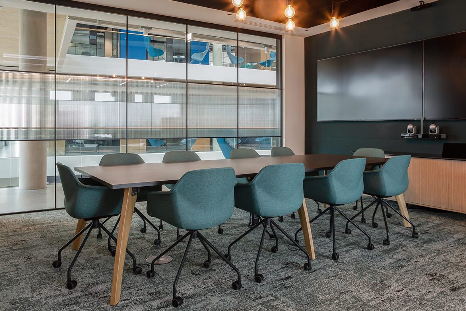 A conference room with a large table and office desk chairs.