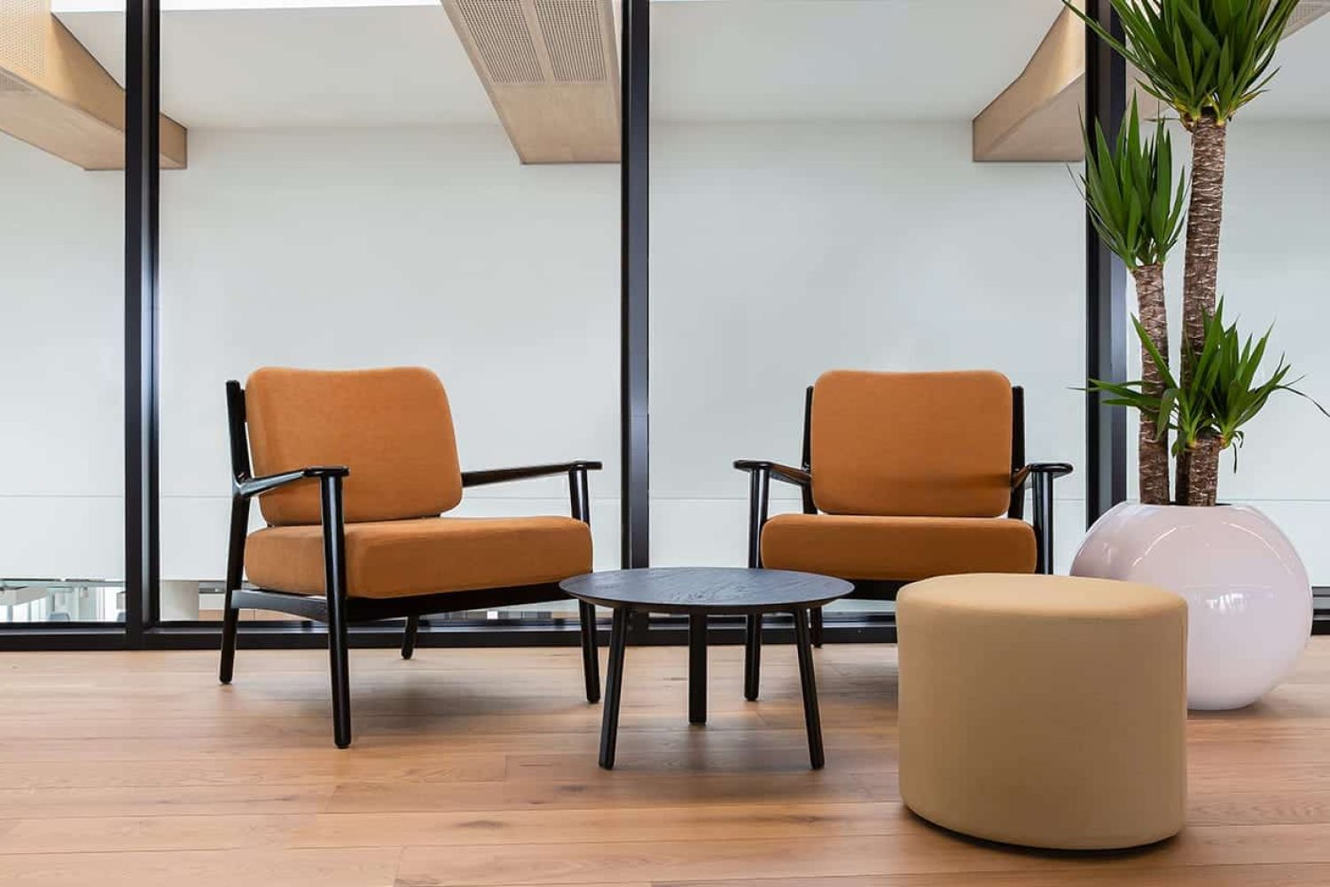 Two lounge chairs for offices in an office with a table in the middle.