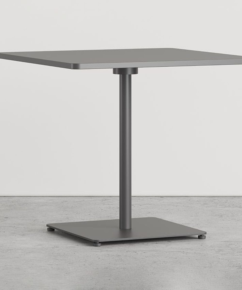 A square pedestal table with a metal base on a concrete floor.