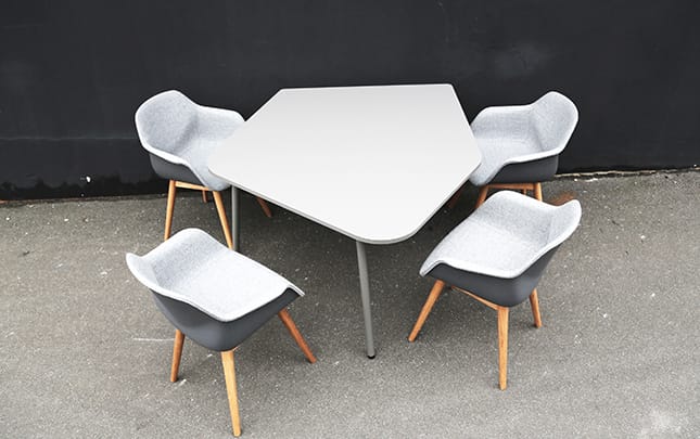 A table with four chairs and a gray table.