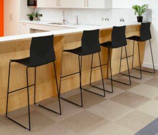 Four black bar counter height chairs in a kitchen against a counter