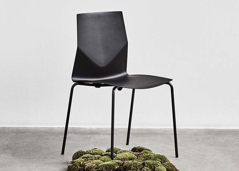 A black chair with moss under it