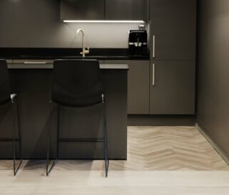 A black and white kitchen with a black bar counter height chairs