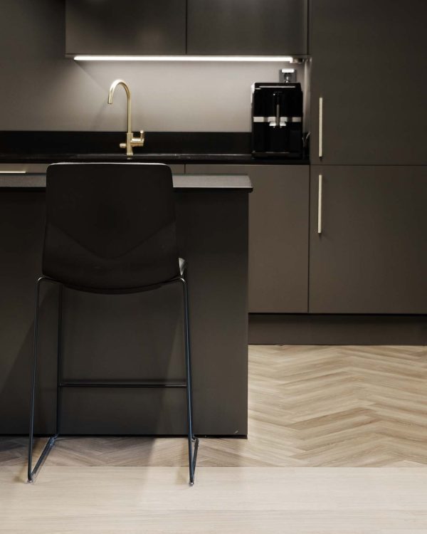 A black and white kitchen with a black bar counter height chairs