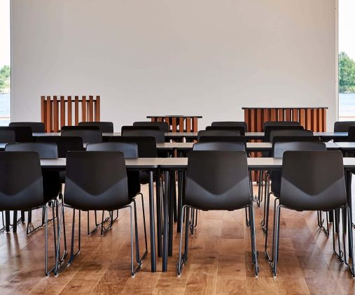 A large room with black office desk chairs