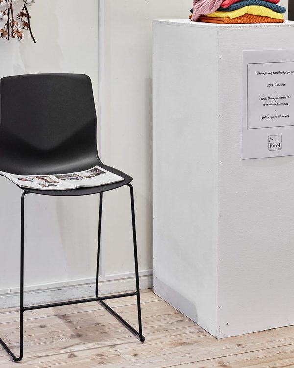 A black and white counter height chair in front of a white box.