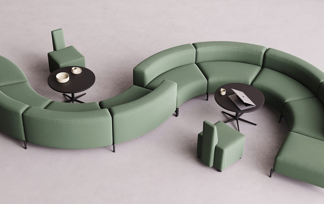 A green curved office sofa with a coffee table in the middle.