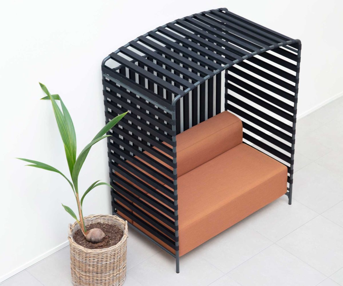 A black slatted bench next to a potted plant.