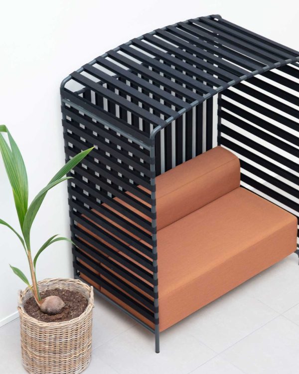 A black slatted bench next to a potted plant.